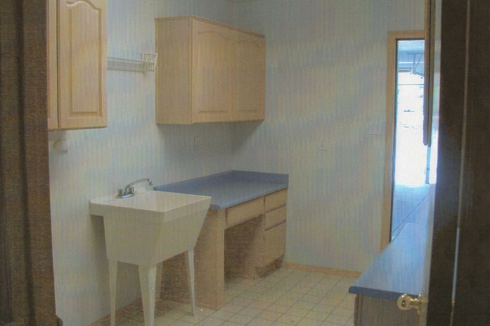 laundry room laundry room has two desks, more cabinets and a deep utility sink.  access to 3-car garage.