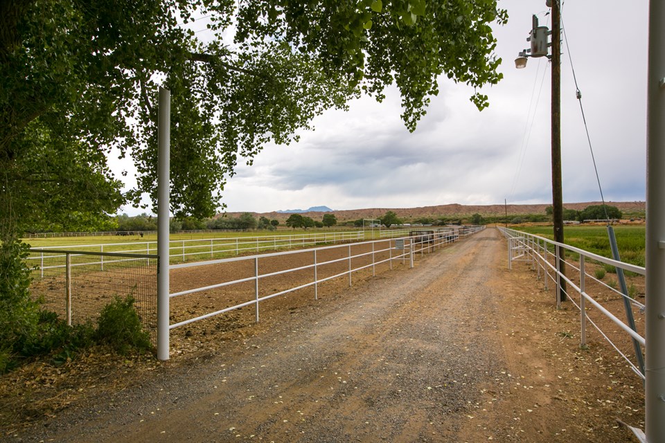 entrance to this 25 acre turnkey horse property home and horse facilities sit to the back of this property.  white pipe fence lines the way.